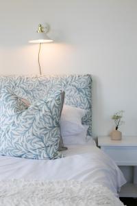 a bed with a blue and white pillow and a lamp at Poole Park House in Poole