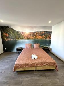 a bedroom with a large bed with a painting on the wall at Le Paris-Vosges in Épinal