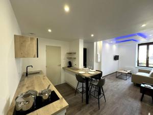 a kitchen and a living room with a table and chairs at Le Paris-Vosges in Épinal