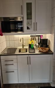 a kitchen with white cabinets and a sink at Zimmer " Sonnenschein" in Zingst