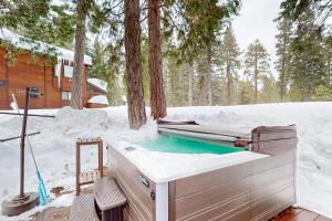 a hot tub in the snow next to a cabin at Blue Skies & Bay Bliss in Carnelian Bay