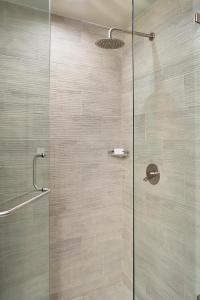 La salle de bains est pourvue d'une douche avec une porte en verre. dans l'établissement Fairfield Inn & Suites by Marriott Aguascalientes, à Aguascalientes