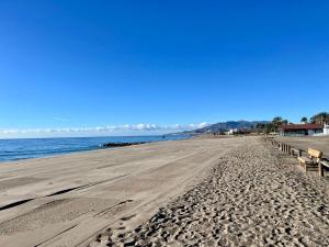 una playa de arena con un muelle y el océano en AquaHome, en Palomares