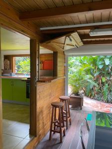 an open kitchen with stools on a deck at Le Filao 2 in Pointe-Noire