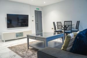 a living room with a glass table and chairs at Stunning 2-Bed Ground Floor Flat in Birmingham in Birmingham