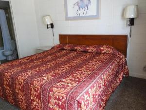 Schlafzimmer mit einem Bett mit einer roten Bettdecke in der Unterkunft SeaGypsy Motel in Myrtle Beach