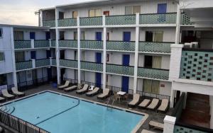 an apartment building with a swimming pool and chairs at SeaGypsy Motel in Myrtle Beach