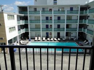 einen Balkon mit Blick auf ein Hotel mit Pool in der Unterkunft SeaGypsy Motel in Myrtle Beach