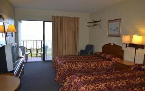 Habitación de hotel con 2 camas y balcón en SeaGypsy Motel, en Myrtle Beach