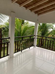 un balcón vacío con vistas a las palmeras en CABAÑA VILLA DEL COCO, en Arboletes
