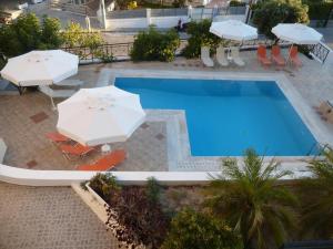 widok na basen z parasolami i krzesłami w obiekcie Anesis Apartments w miejscowości Agia Marina