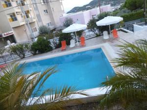duży niebieski basen z leżakami i parasolami w obiekcie Anesis Apartments w miejscowości Agia Marina