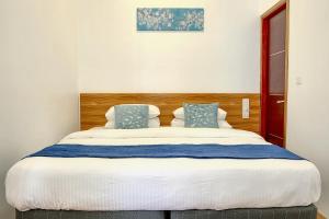 a bedroom with a large bed with blue pillows at Manta Sky Inn in Dharavandhoo