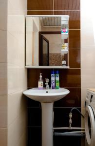 a bathroom with a white sink and a mirror at 2 комнатная квартира, по суточно, напротив ТД Сырымбет in Kokshetau