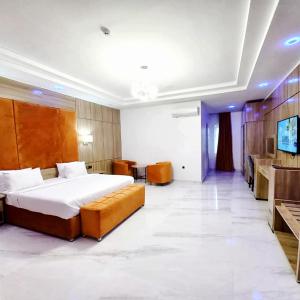 ウヨにある1401 Luxury Apartmentのベッドとテレビが備わるホテルルームです。