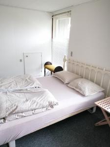 een wit bed in een kamer met een raam bij Indkvatering Filskov in Grindsted