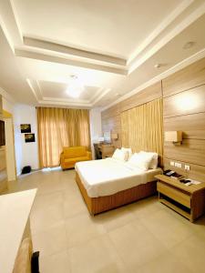 ein Schlafzimmer mit einem großen Bett und einem gelben Stuhl in der Unterkunft 1401 Luxury Apartment in Uyo