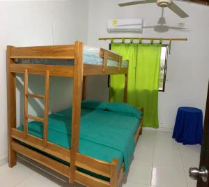 CABAÑA VILLA DEL COCO في أربوليتيه: سرير بطابقين في غرفة مع ستارة خضراء