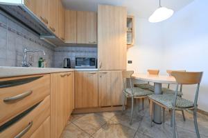 a kitchen with wooden cabinets and a table and chairs at Casa Lief in Mazzin +16 photos