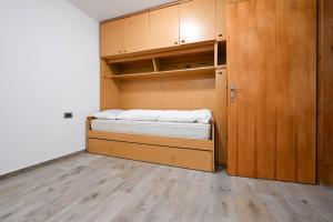 a small bedroom with a bed and wooden cabinets at Casa Lief in Mazzin