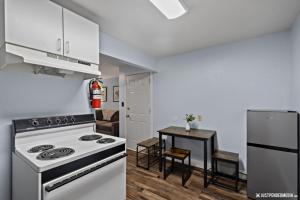 uma cozinha com um fogão e uma pequena mesa em White Raven Perch - Westwood 7 em Anchorage