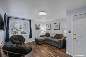 uma sala de estar com um sofá e uma cadeira em White Raven Perch - Westwood 7 em Anchorage