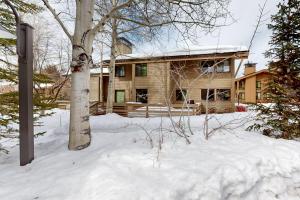 a house with a tree in the snow at Creekside 1274 in Sun Valley