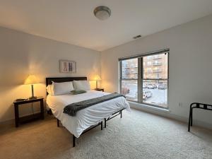 a bedroom with a bed and a large window at Flexhome Third Ward 1BR J1 with Gym and Balcony - READ INFO in Milwaukee