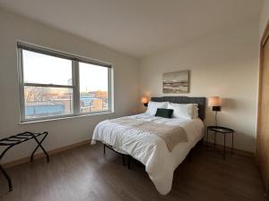 een slaapkamer met een bed en een groot raam bij Flexhome Walkers Point 2BR T3 with Gym and Balcony - READ INFO in Milwaukee