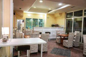 a restaurant with tables and chairs and a kitchen at Primus Apartments in Visoko