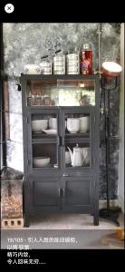 une armoire grise remplie de plats et d'assiettes dans l'établissement memory corner, à Ipoh