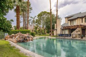 a swimming pool in a yard with palm trees at Lola's Casa Azul #4313 in Palm Springs