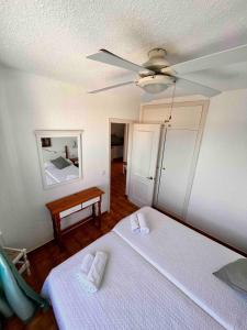 um quarto com uma cama e uma ventoinha de tecto em Apartamento 107 Castell Sol CB em Arenal d'en Castell