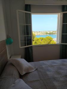 a bedroom with a window with a view of the water at Apartamento 107 Castell Sol CB in Arenal d'en Castell