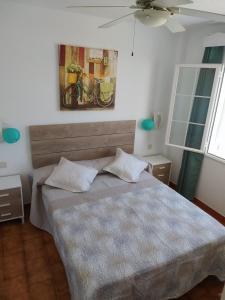 a bedroom with a bed and a painting on the wall at Apartamento 107 Castell Sol CB in Arenal d'en Castell