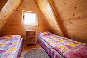 2 camas en una cabaña de madera con ventana en Domki Niegowa, en Niegowa