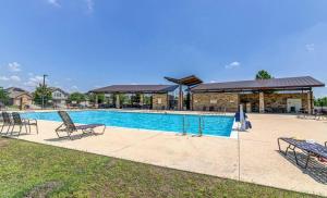 a swimming pool with chairs and a building at Serenity Home Near Downtown & Airport in Austin