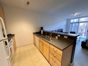 a kitchen with a sink and a refrigerator at Flexhome Third Ward 1BR J2 with Gym and Balcony - READ INFO in Milwaukee