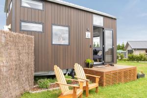 een tiny house met een terras en twee stoelen bij Tataraimaka Farmlet in Tataraimaka