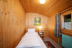 ein Schlafzimmer mit einem Bett in einem Holzzimmer in der Unterkunft Apartment im Chalet Sidonie in Amden