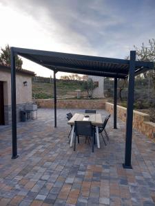 a picnic table and chairs under a canopy on a patio at Los Pinos Munera in Munera