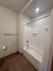 uma casa de banho branca com um chuveiro e uma banheira em Flexhome East Side 1BR R2 - Brady Fiserv Balcony - READ INFO em Milwaukee