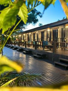 a building with benches and tables on a deck at Pousada Piraúna in Fernando de Noronha