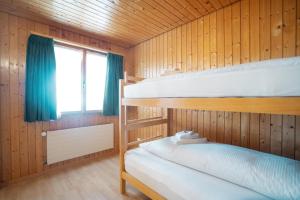 2 letti a castello in una cabina di legno con finestra di Apartment Bergdohle ad Amden