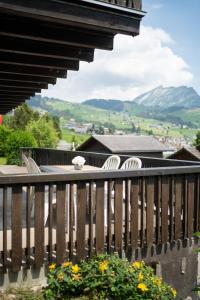einen Balkon mit einem Tisch, Stühlen und Bergen in der Unterkunft Apartment Bergdohle in Amden