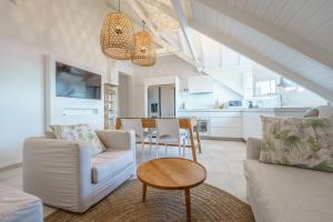 a living room with white furniture and a table at Luxe pleine vue mer et plage in Saint-François