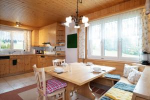 cocina y comedor con mesa de madera y sillas en Ferienhaus Bergblick en Amden