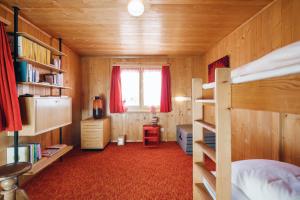 a bedroom with two bunk beds and a window at Chalet Engihalde in Amden