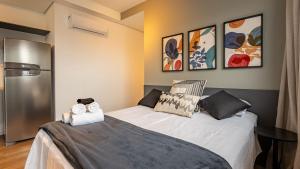 a small bedroom with a bed and a refrigerator at Studio completo próx. estação Fradique Coutinho in Sao Paulo +27 photos