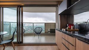 uma cozinha com 2 cadeiras e uma grande janela em Studio lindo em Pinheiros prox estação Fradique Coutinho em São Paulo